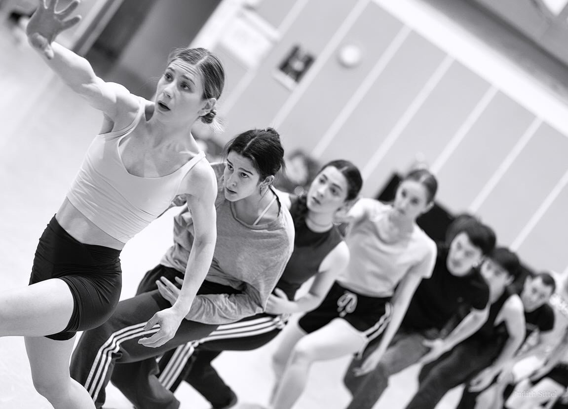 Dancers working together in a rehearsal studio.