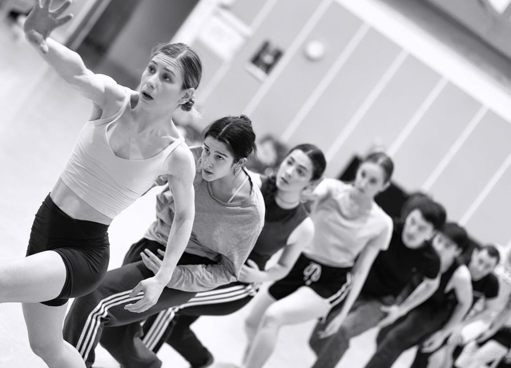 Dancers working together in a rehearsal studio.